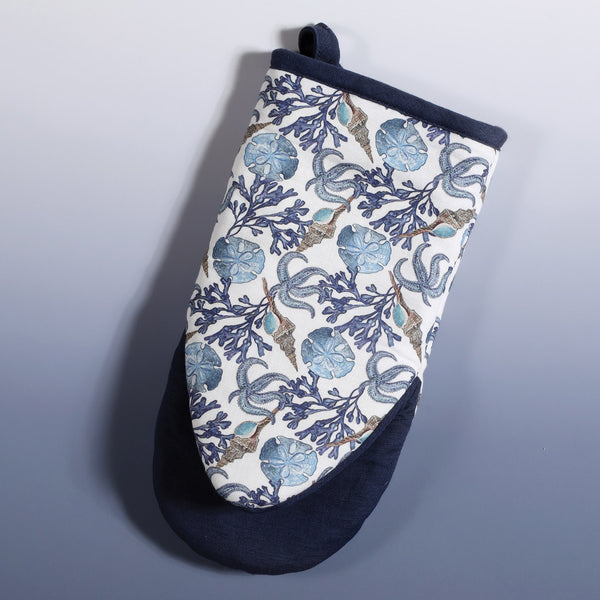 Reverse side of Cotton and Linen mix oven mitt with hand drawn mini illustrations of Starfish,Sand dollar,seaweed and a whelk shell in shades of blue with a navy trim