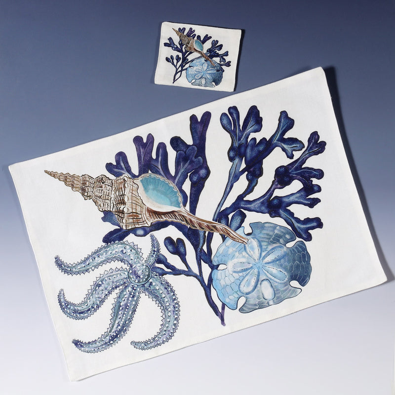 Cotton and linen mix white fabric rectangular placemat.Design on both sides is hand drawn seaweed,a sand dollar in shades of blue .Set of four