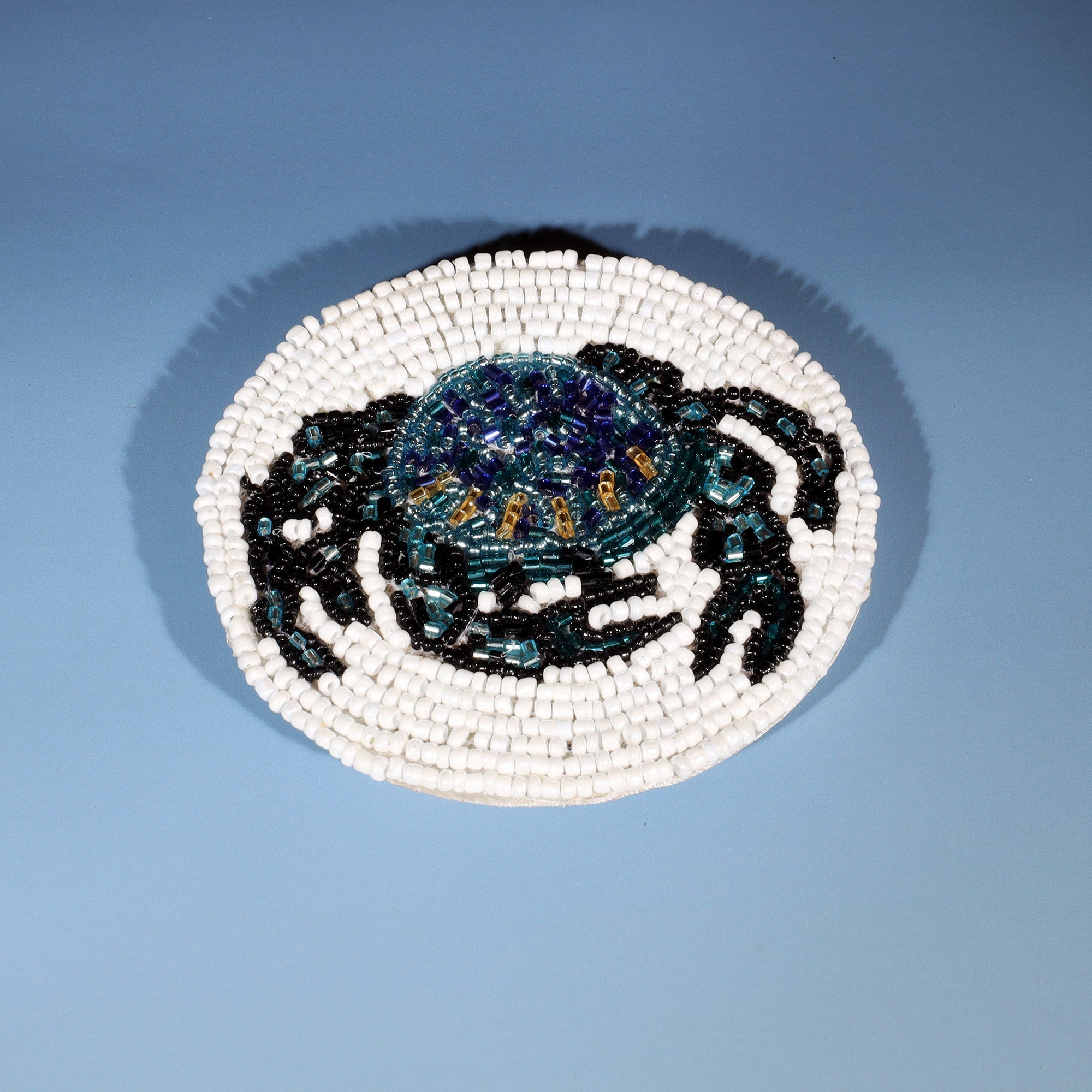 Handmade glass beaded coaster with a crab design in Navy,Black and gold on  white glass beads