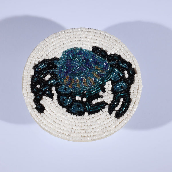 Handmade glass beaded coaster with a crab design in Navy,Black and gold on  white glass beads