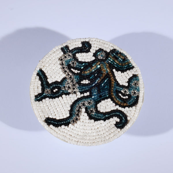 Handmade glass beaded coaster with an Octopus design in Navy,Black and gold on white glass beads