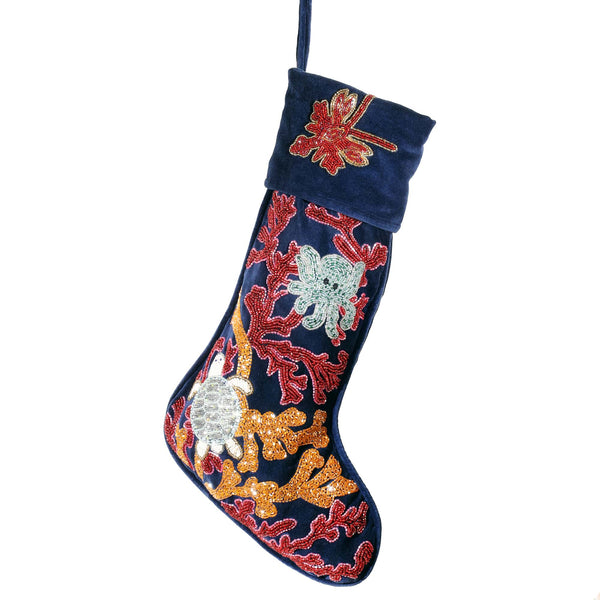 dark blue velvet christmas stocking with red and orange beaded coral and seaweed and turtle, octopus and lobster floating in amongst it.