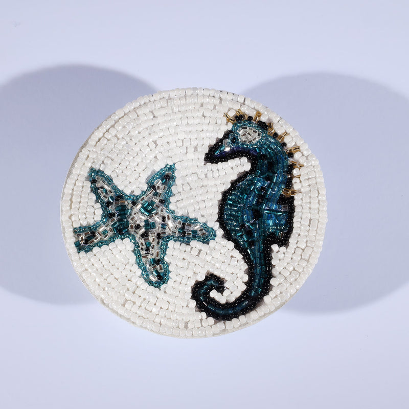 Handmade glass beaded coaster with a Seahorse and Starfish design in Navy,Black and gold on white glass beads