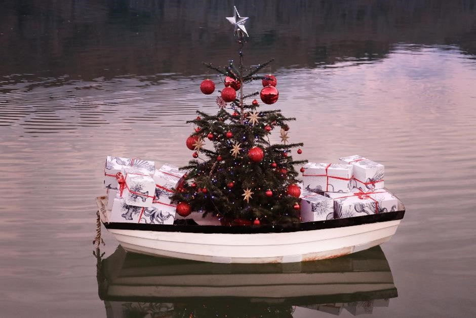 Gifts aboard a boat decorated with a Christmas tree on Fal River