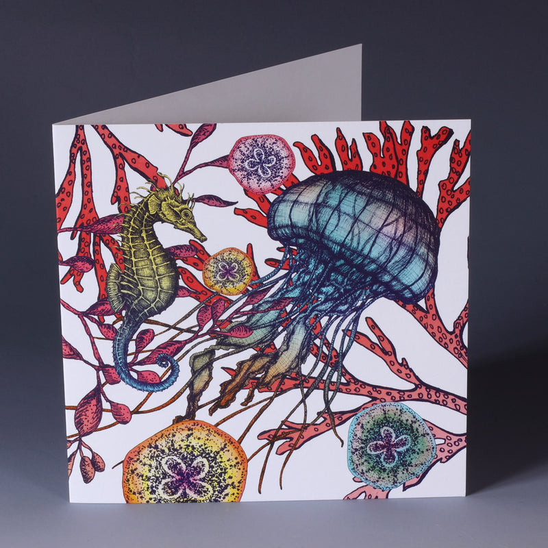 brightly coloured greeting card with jellyfish, seahorse and sea coral with baby jellyfish on a white background