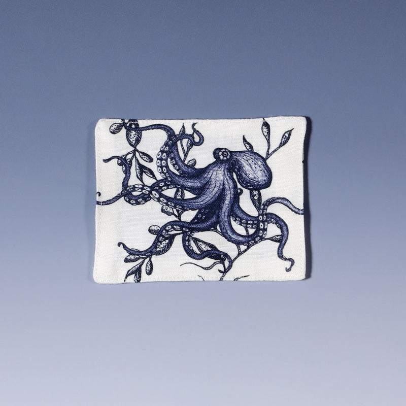 Cotton and linen mix white fabric rectangular coaster.Design on both sides is a hand drawn illustration of an octopus  in seaweed in navy blue.Set of four