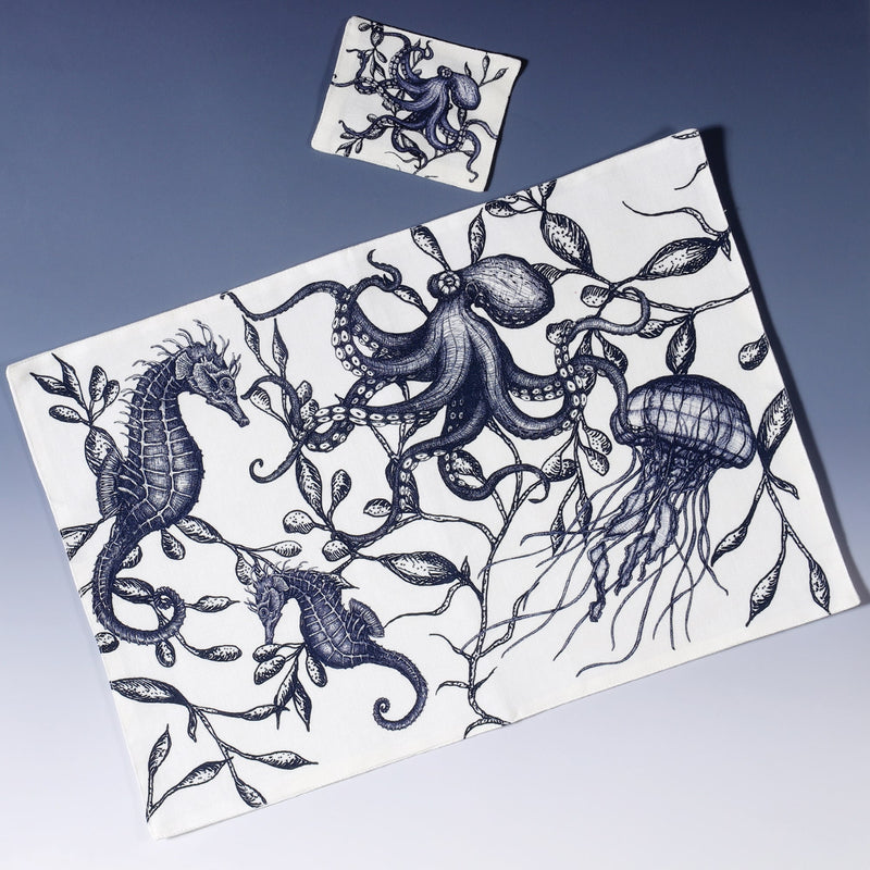 Cotton and linen mix white fabric rectangular placemat.Design on both sides is hand drawn sea creatures in shades of blue .Set of four