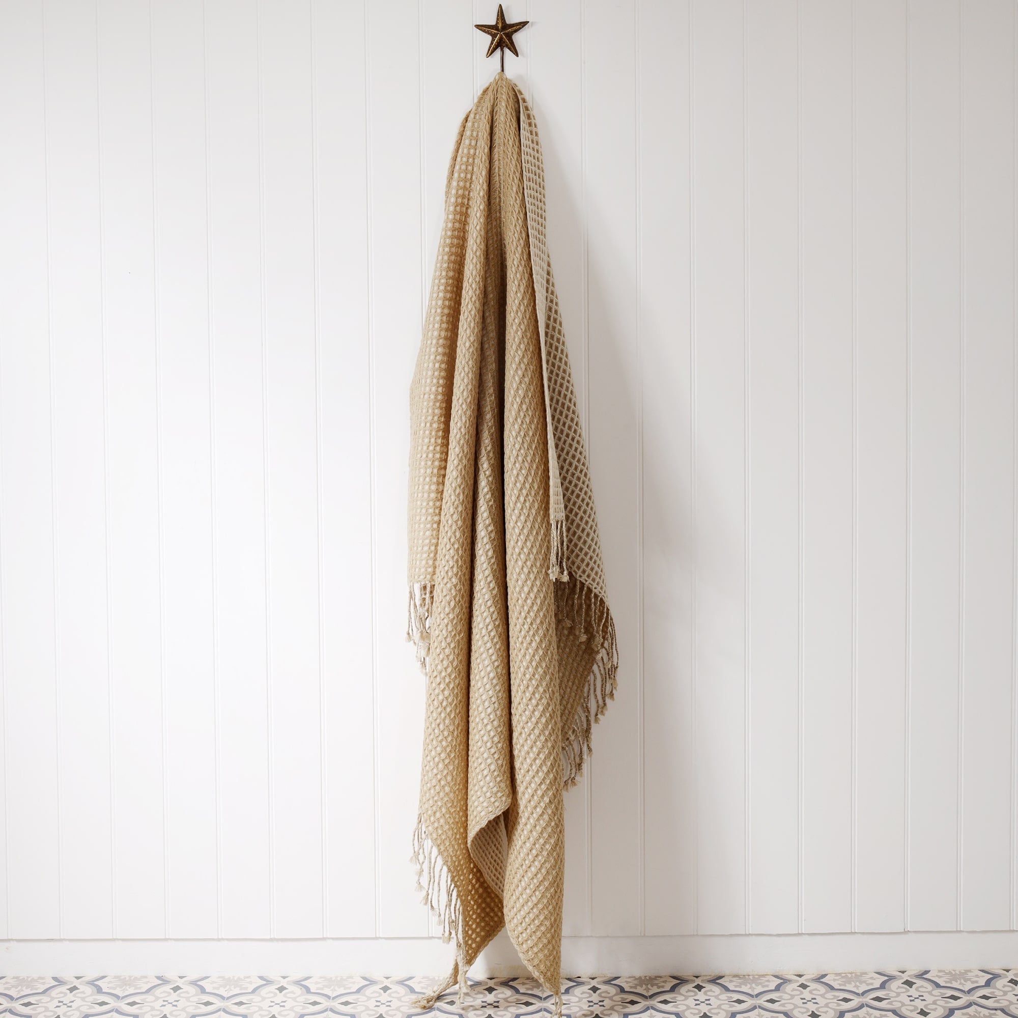 double faced throw with natural colour one side and cream the other in a honeycomb pattern, hanging on a star fish hook