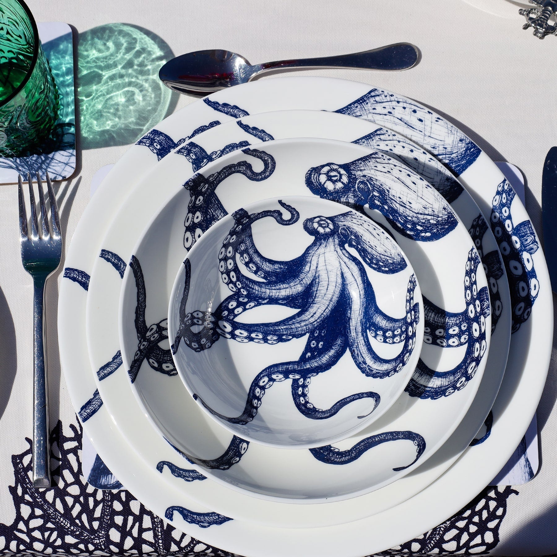 Aerial view of Bone China White plate with hand drawn illustrations of our classic Octopus in Navy stacked with the large dinner plate,pasta bowl and cereal bowl