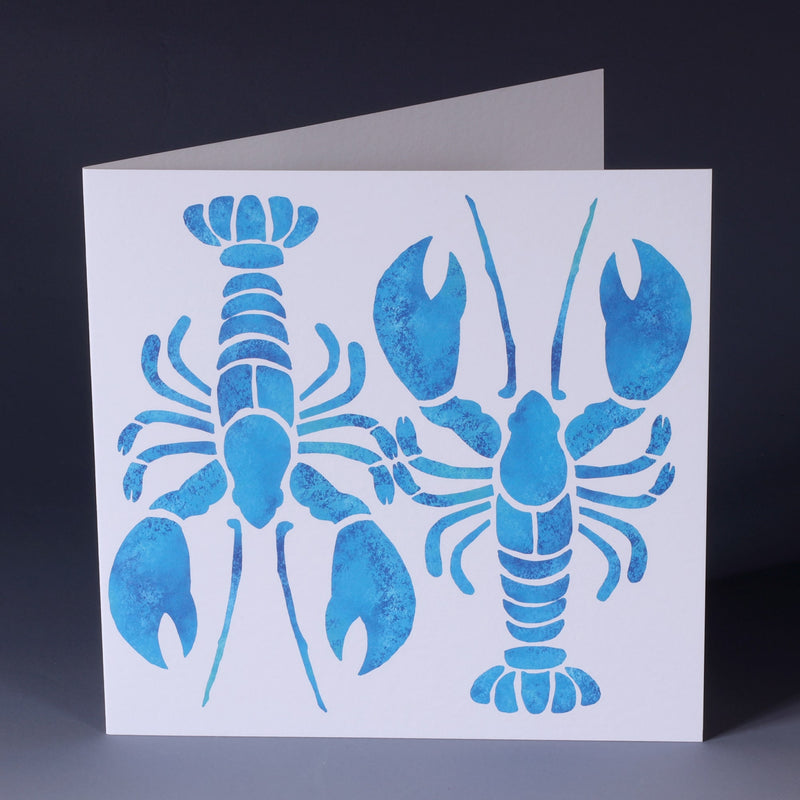 greeting card with 2 turquoise illustrated lobsters one facing up and the other facing down, abstract and filled with a mottled blue effect on a white background