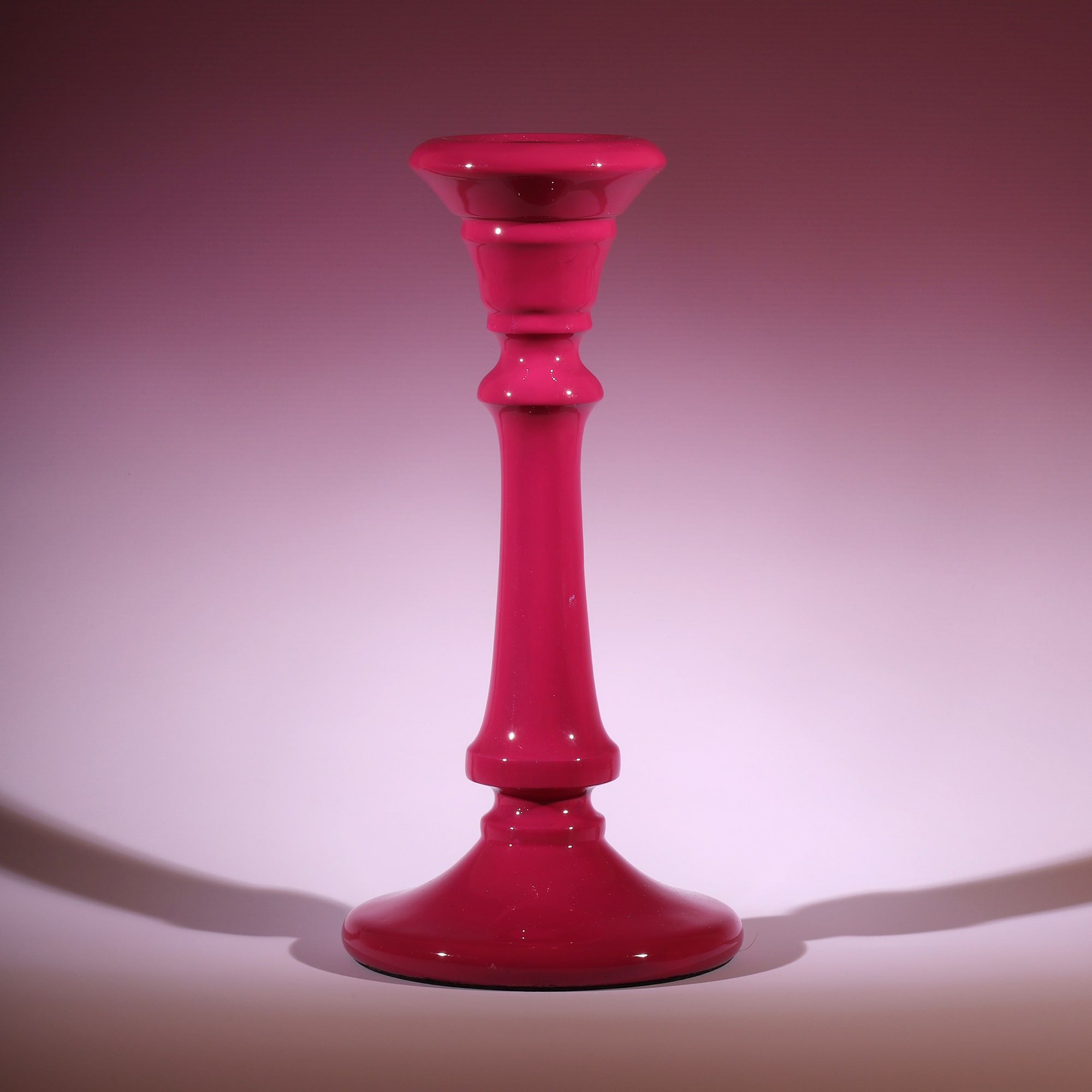 Fuschia Polished Lacquer Candle holder,tapered at the top,moving down it has various section and a long smooth piece to finish with a tapered base