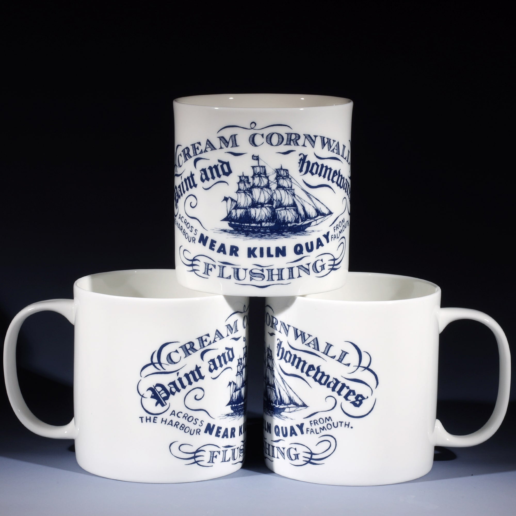 3 extra large 1 pint white bone china mugs. 2 at the bottom and one on top so that all the different sides of the design are shown. The design in navy blue is inspired by vintage maritime illustrations of ships maritime documentation with the place name Kiln Quay at the bottom.