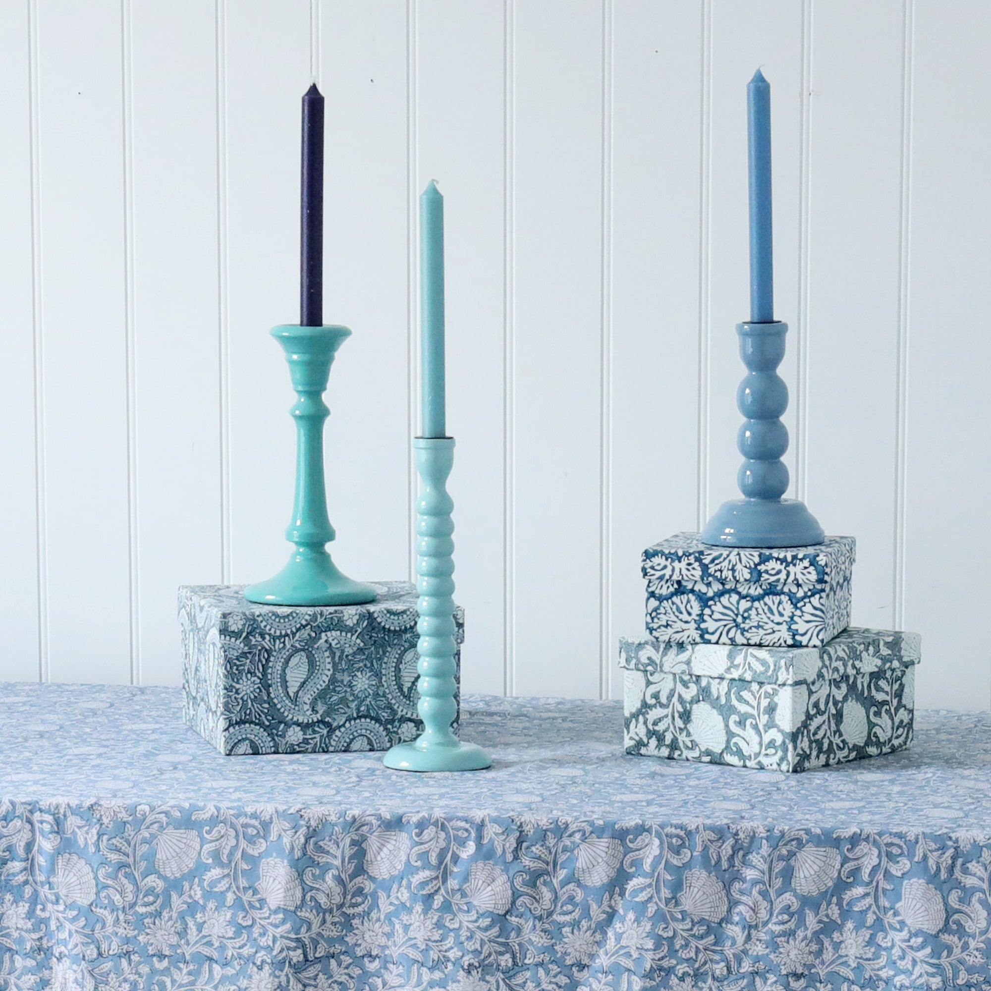 Turquoise Tidal Candle holder placed a box on one of our Samudra linen collection table cloths.Also on the table are other candle holders placed on our hand painted boxes,each have matching candles