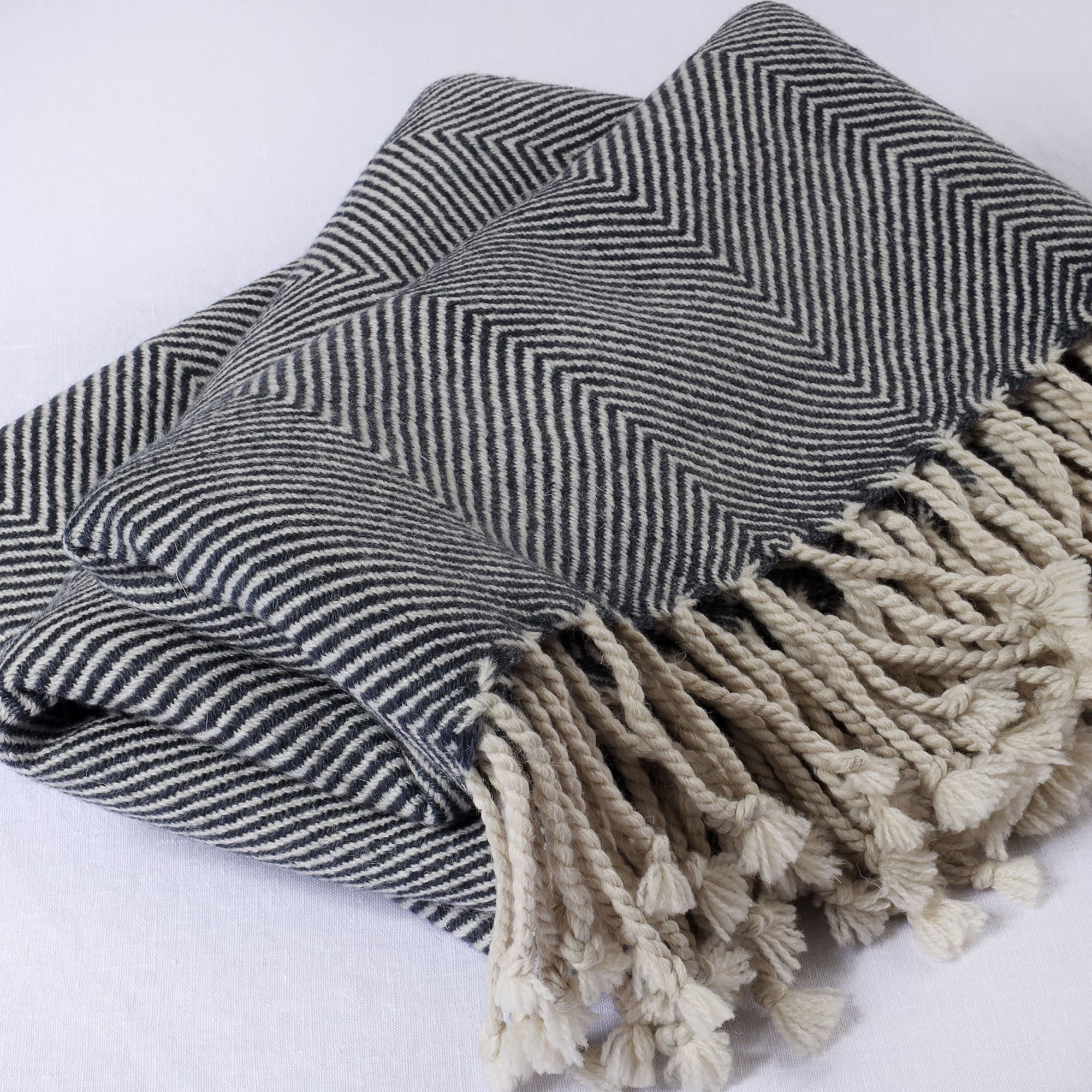 folded navy & cream herringbone throw on a white background showing the weave detail and the knotted tassel fringe 