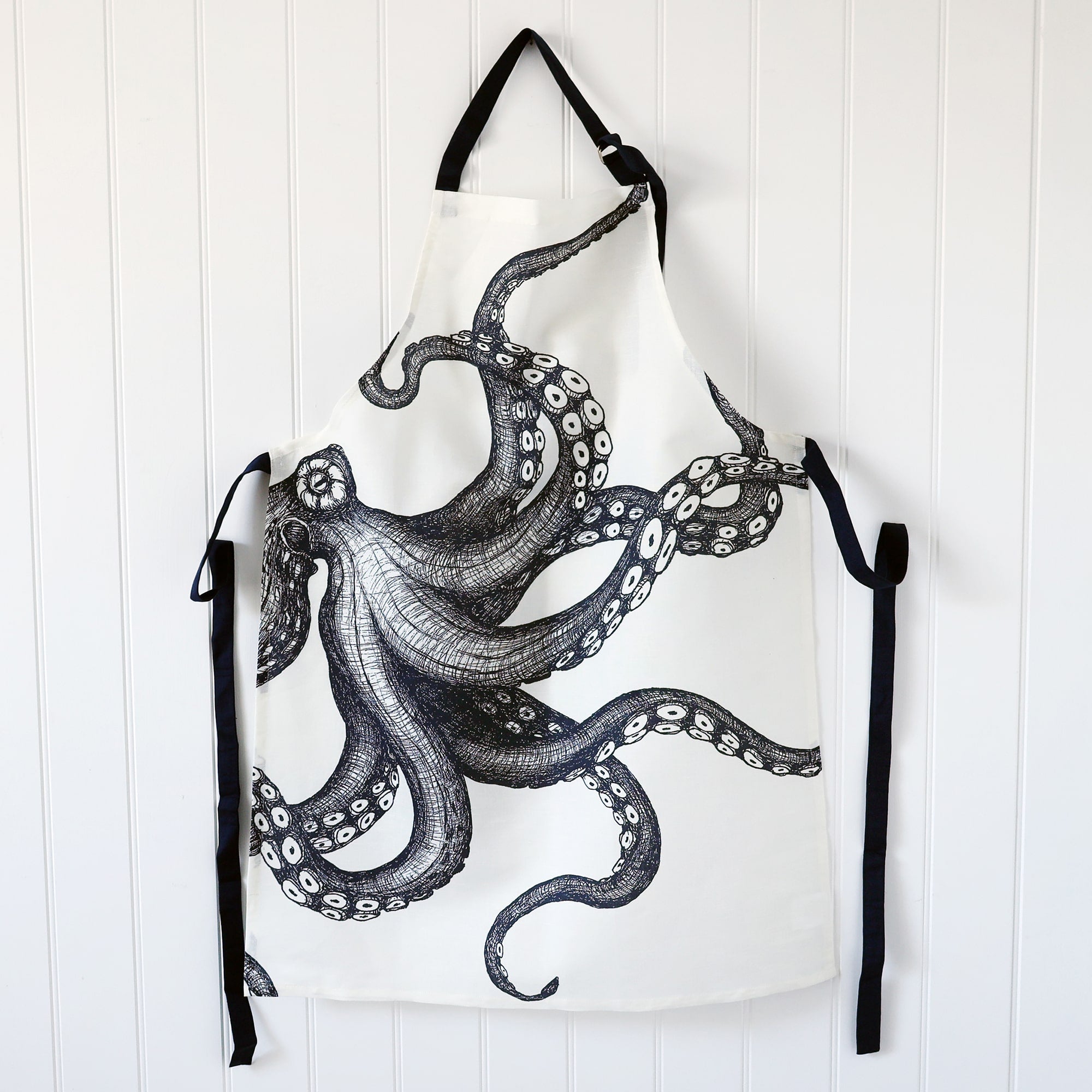 White Linen/Cotton mix apron with navy ties and Navy strap around the neck,this can be adjusted to fit.On the print is our Octopus design.