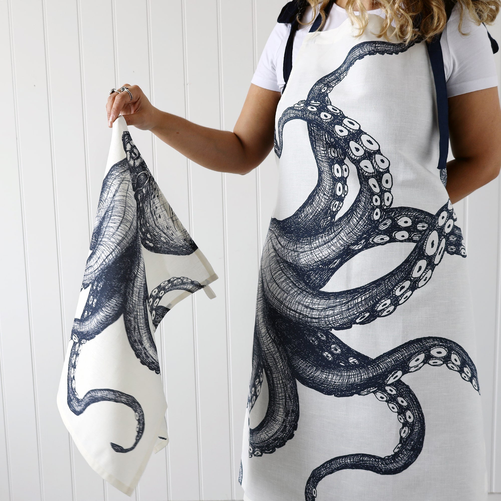Model wearing our Octopus Apron holding  a matching tea towel 