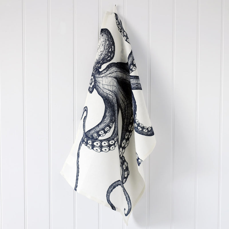 Cotton and Linen Octopus Tea towel decorated with hand drawn design in shades of blue on a white background hanging from a hook