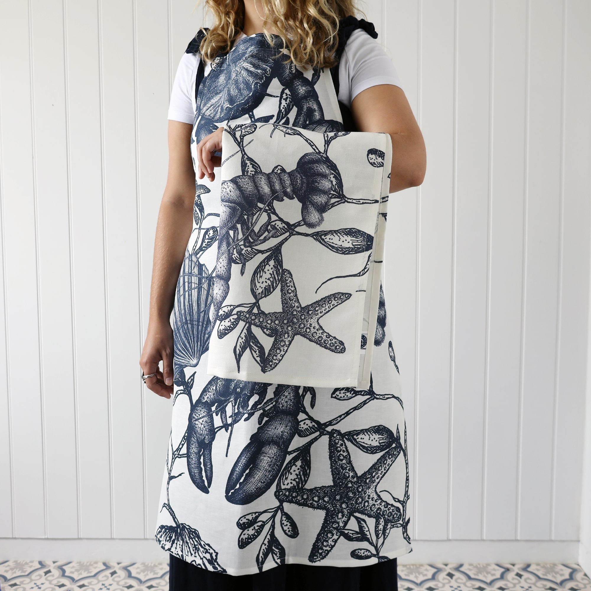 Model wearing our Sea creature  Aprion with a matching tea towel over her arm