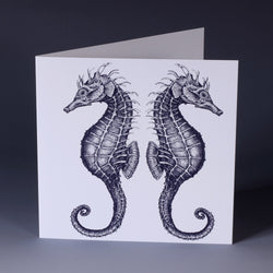 greeting card with illustrated navy seahorses back to back on a white background
