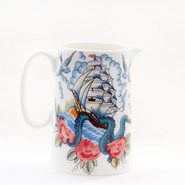 Product shot of a white jug with a ship, kraken and roses design that is inspired by sailor's tattoos.