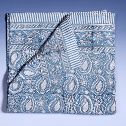 Azure Paisley Shell Tablecloth which is Hand block printed fabric in a soft blue and white, the print is a repeat paisley with a shell theme throughout with swirling flowers.Edging is soft blue and white stripe