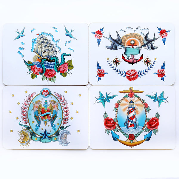 Product shot of set of 4 placemats each with a different brightly coloured design based on sailor's tattoos. There is a ship, kraken and roses design, a swallows and anchor, mermaids with a heart & dagger and a lighthouse with kraken and roses.
