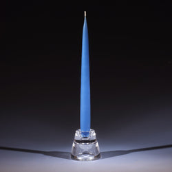 wedgewood blue tapered dinner candle in a small glass candle holder on an ombre blue background