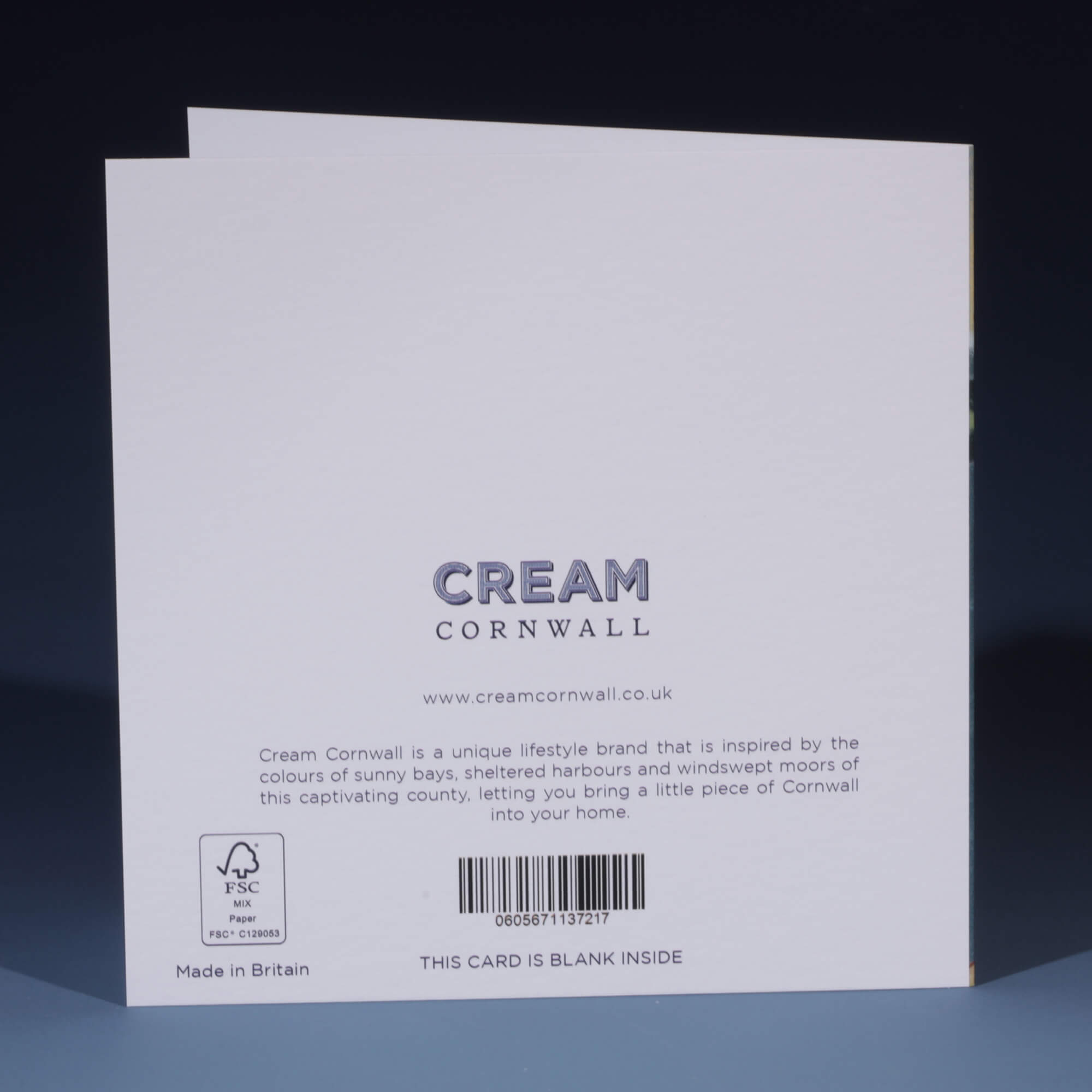 The back of a Cream Cornwall greeting card, featuring the brand's logo and website, www.creamcornwall.co.uk. The text describes the brand as inspired by the colors of Cornwall's sunny bays, sheltered harbors, and windswept moors. An FSC-certified paper symbol is visible in the bottom left corner, along with a barcode. The message at the bottom states, 'THIS CARD IS BLANK INSIDE,' and the card is labeled 'Made in Britain.'