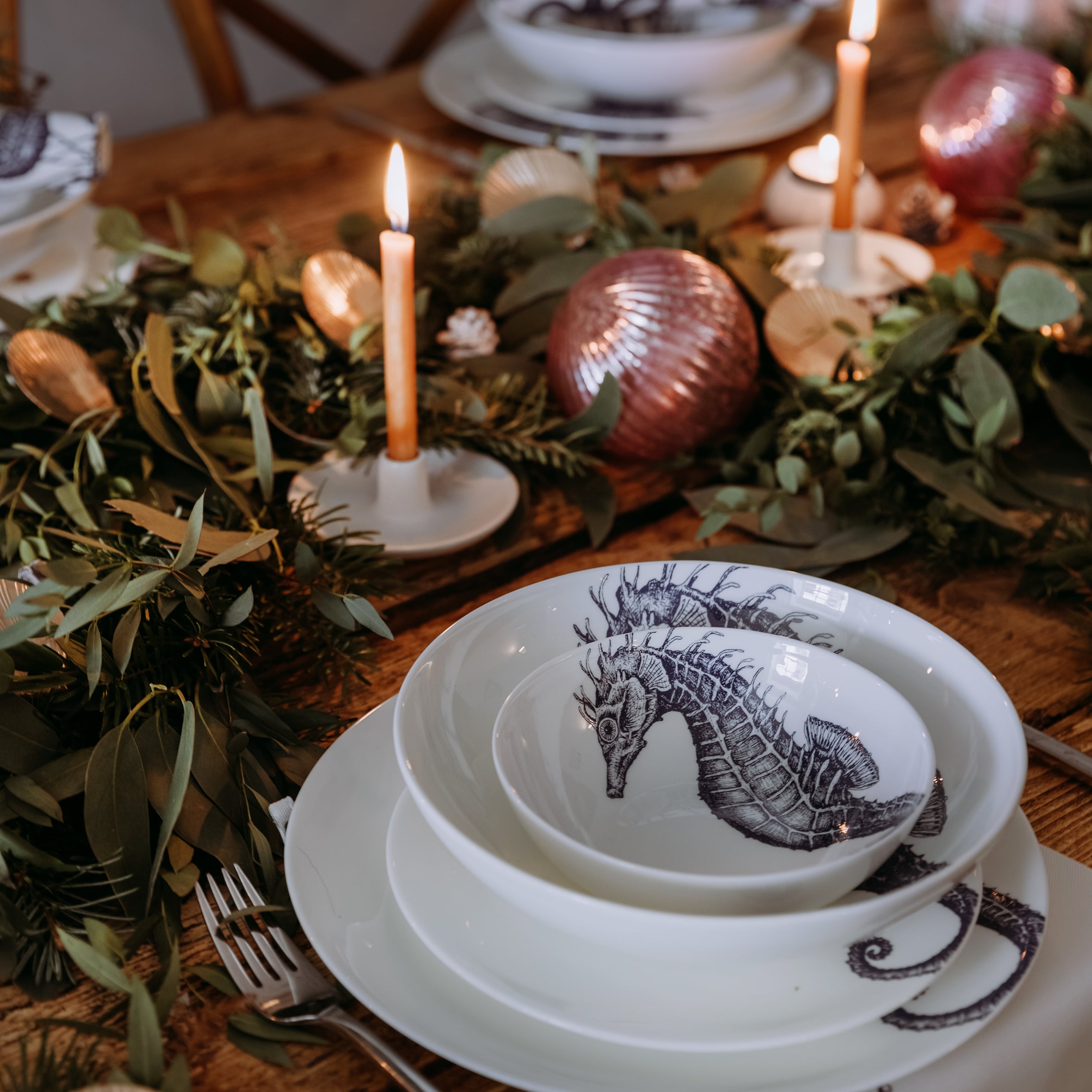 Pasta bowl in Bone China in our Classic range in Navy and white in the Jellyfish design,placed on a matching dinner plate and has a smaller bowl placed inside.All are on a table setting and the table is decorated with foliage and candle holders