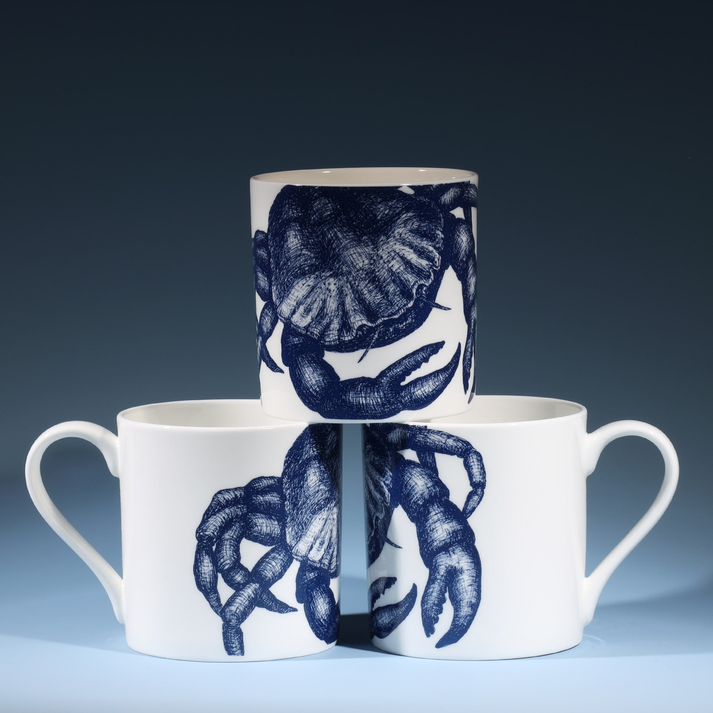 Bone china white mug featuring hand drawn Crab  design in classic Navy stacked in three showing all sides of the design..