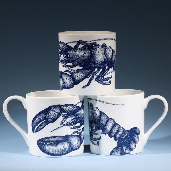 The photo shows Bone china white mug featuring hand drawn lobster design in classic Navy,three of them stacked up showing the different sides