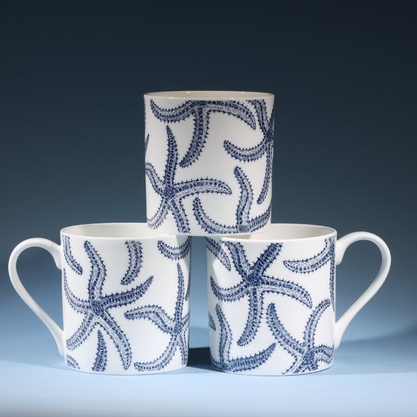 Bone china white mug featuring hand drawn Starfish design in classic navy in a stack of three