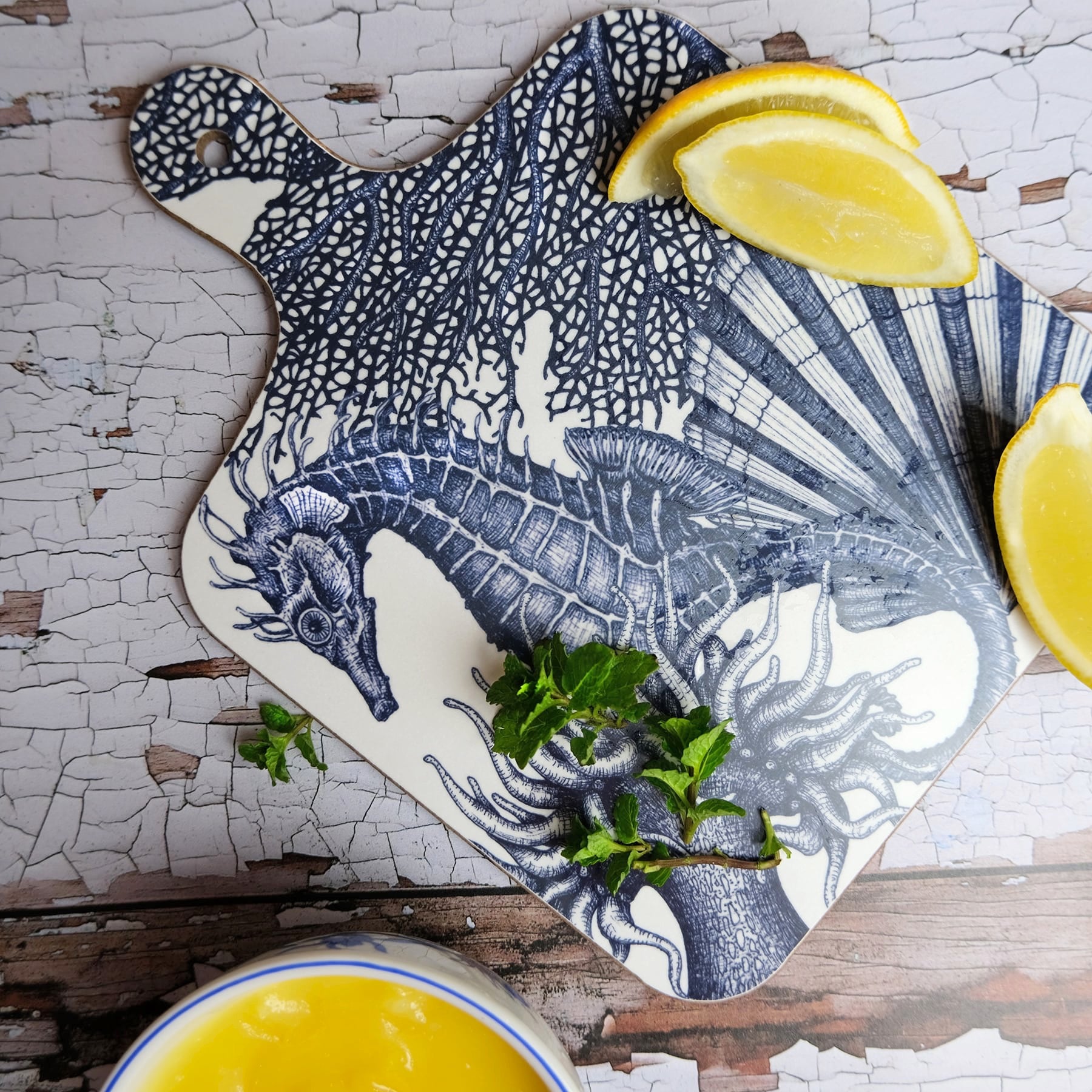 Seahorse mini chopping board placed on a table with sliced lemons 