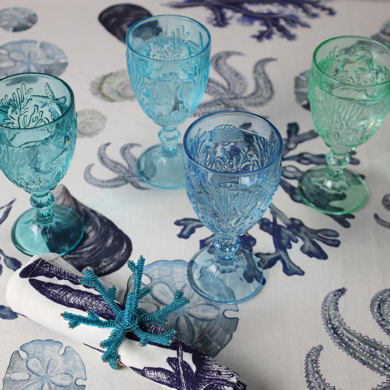 Set of 4 Underwater Goblets in four different shades of blues with embossed sea creatures in the glasses all set on a Beachcomber table cloth