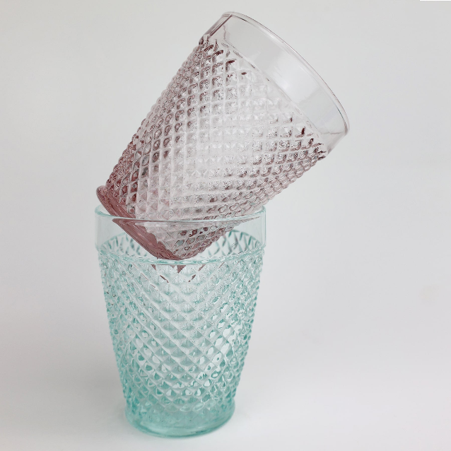 Aqua coloured Diamond cut glass tumbler with a rose glass stacked at an angle on top