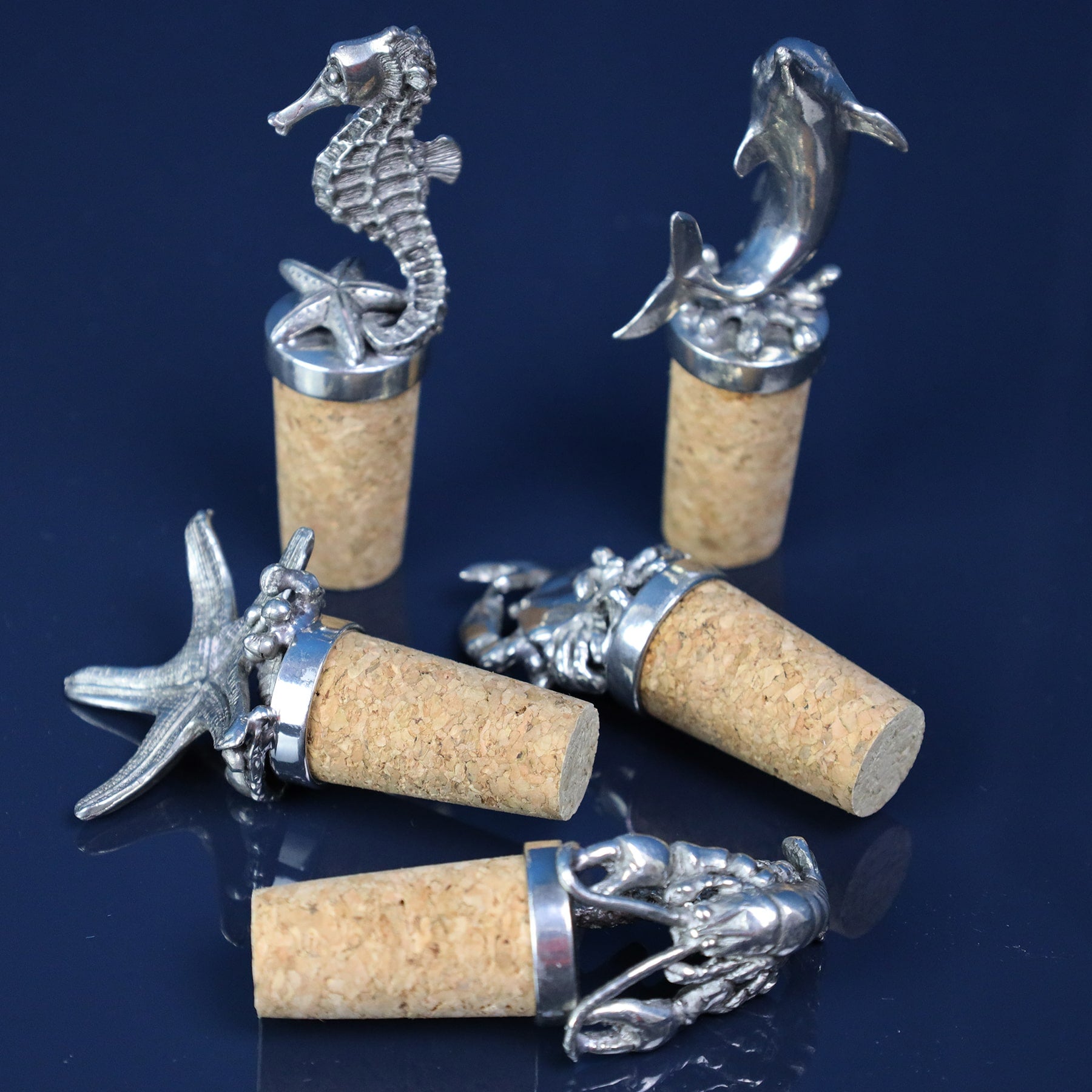 Seahorse,Starfish,Crab,Lobster and Dolphin Cork Stopper all lined up on a table, some lying on their side