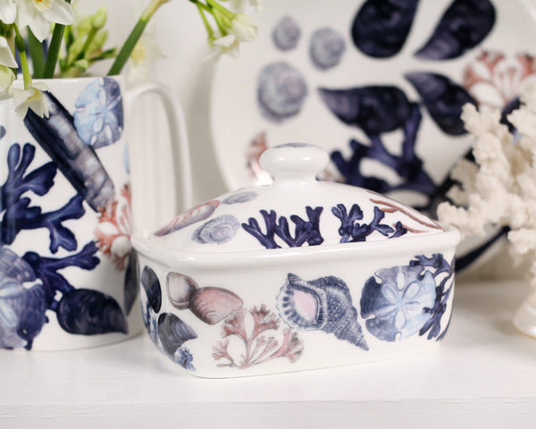 Butter dish in our Beachcomber range,with shells,seaweed and other sea themed designs all over the base and the lid,behind are matching Jugs and a Beachcomber plate