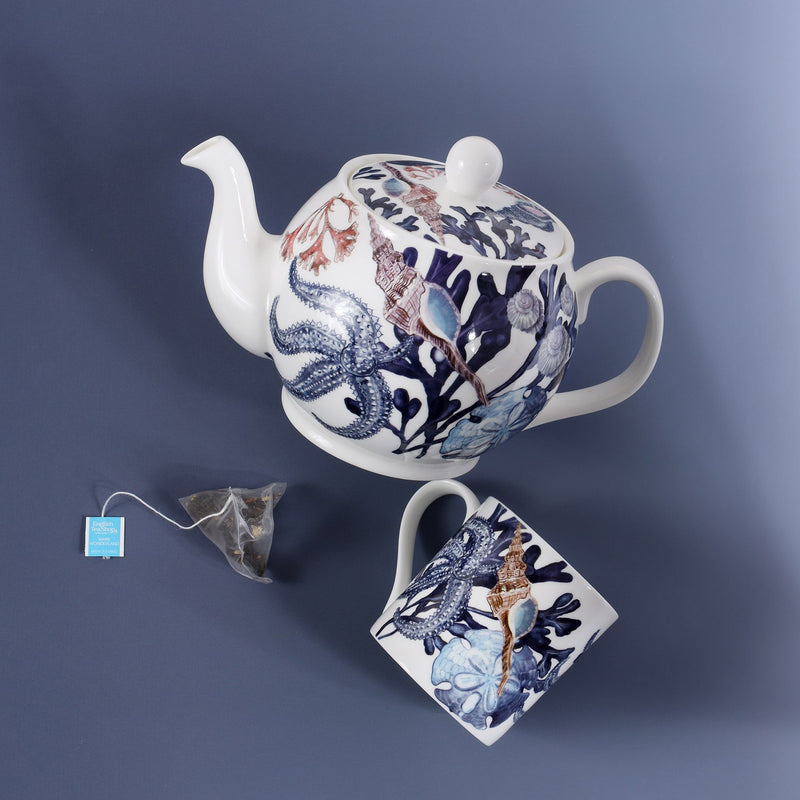 Bone China Teapot with hand drawn design in our beachcomber range from above.Next to it is a mug and a triangle herbal tea bag ready to make a cuppa with