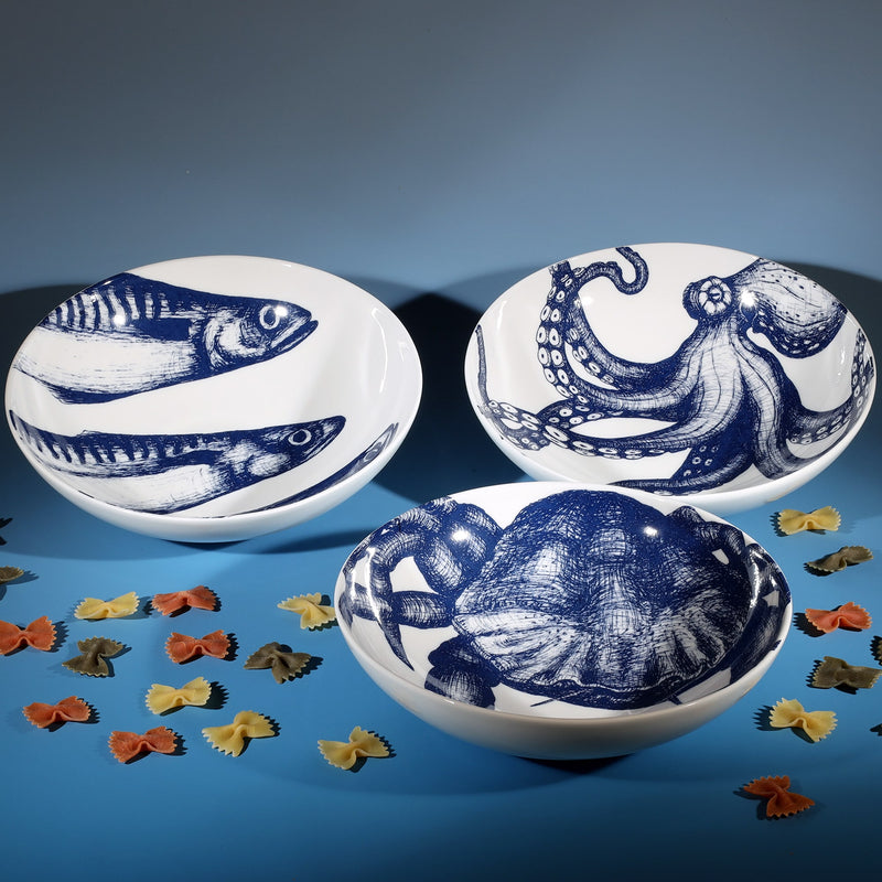 Pasta bowl in Bone China in our Classic range in Navy and white in the Mackerel  design next to a Crab and an Octopus bowl.In between them are several pieces of decorative colourful pasta