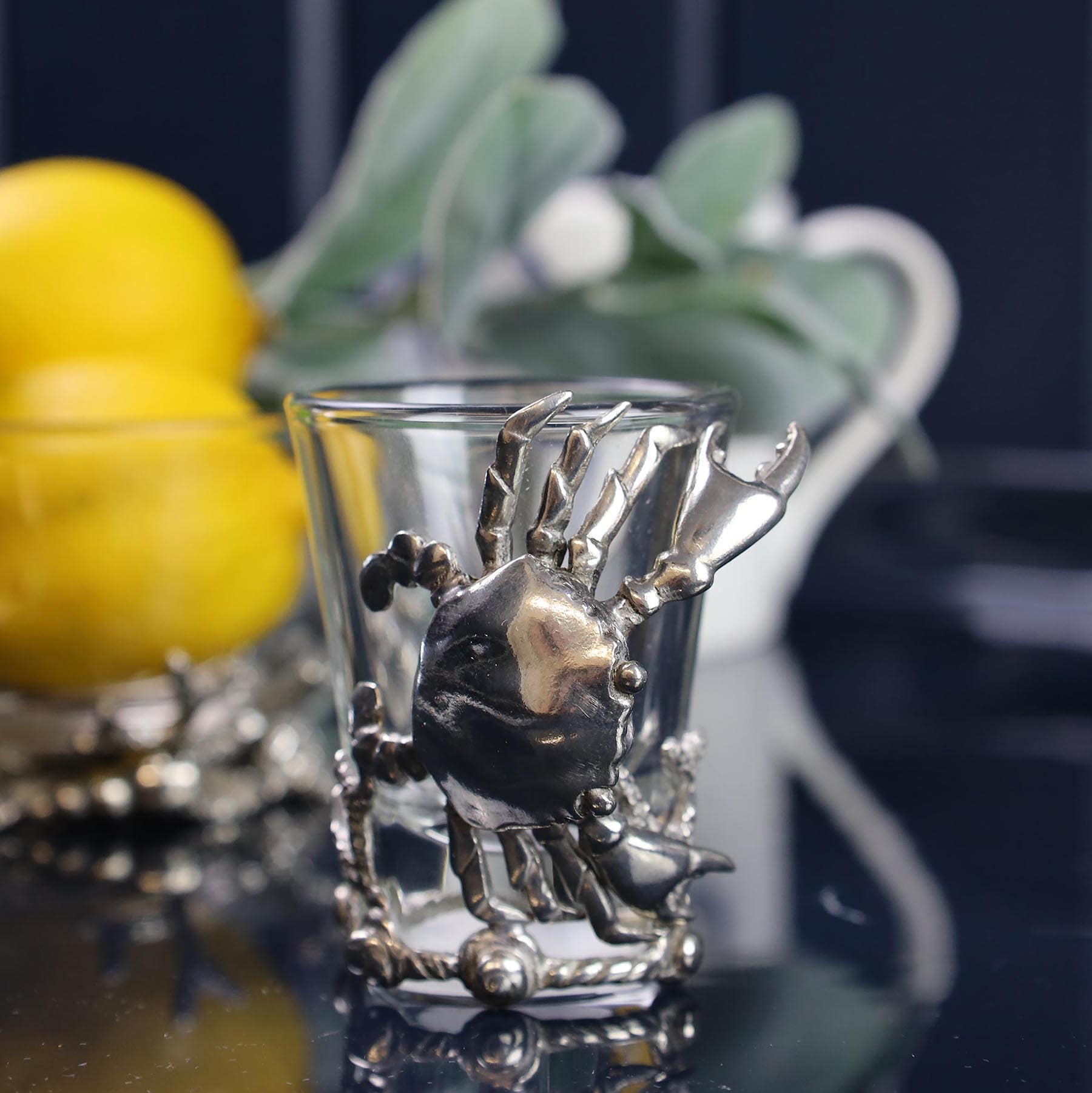 Pewter Crab Shot Glass on a mirror table in front of a bowl with lemons in