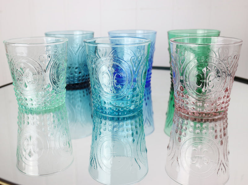 Different coloured Fleur de Lys Tumblers on a mirror top table