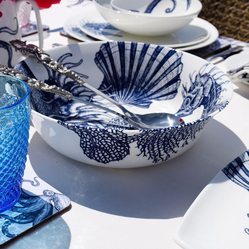 Serving bowl in Bone China in our Classic range in Navy and white in the Seahorse design on a white tablecloth,with a pair of Pewter salad servers in the bowl,also on the table are other Cream pieces of tableware