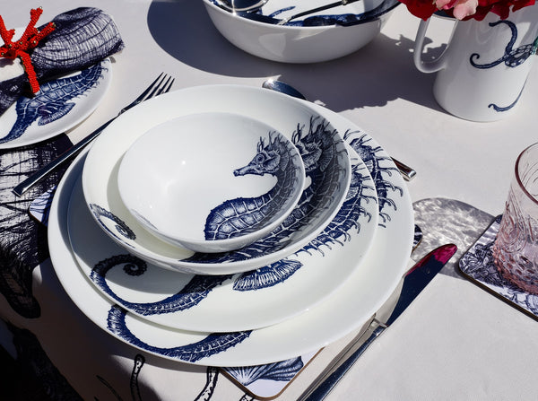 Aerial view of Bone China White plate with hand drawn illustrations of our classic Seahorse in Navy stacked with the large dinner plate,pasta bowl and cereal bowl