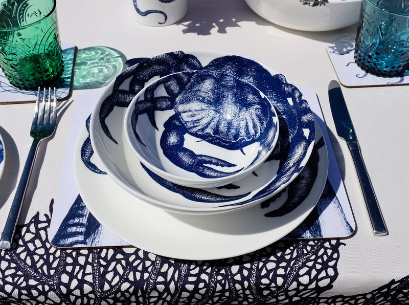 Aerial view of Bone China White plate with hand drawn illustrations of our classic Crab in Navy stacked with the pasta bowl and cereal bowl