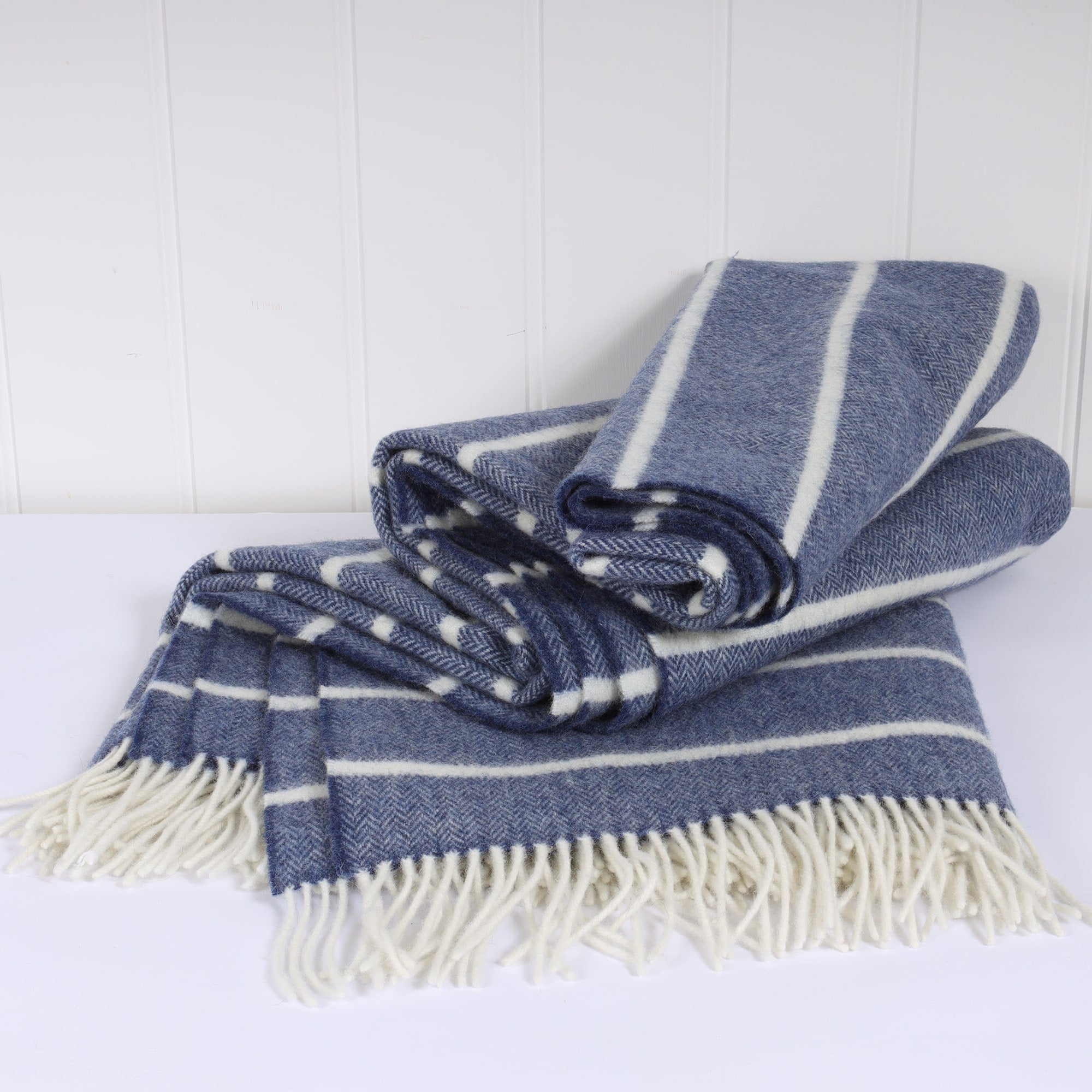 Lambswool Denim and White striped throw folded on a table