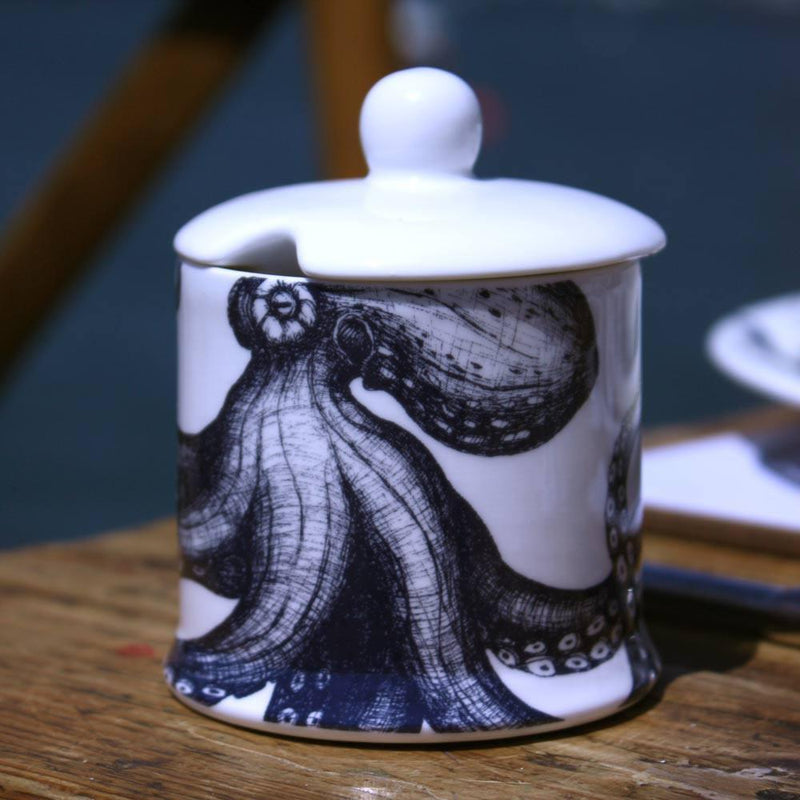 Jam Pot with lid in our classic range in the Octopus design with a space in the lid for a tea spoon on a wooden table with the sea in the background