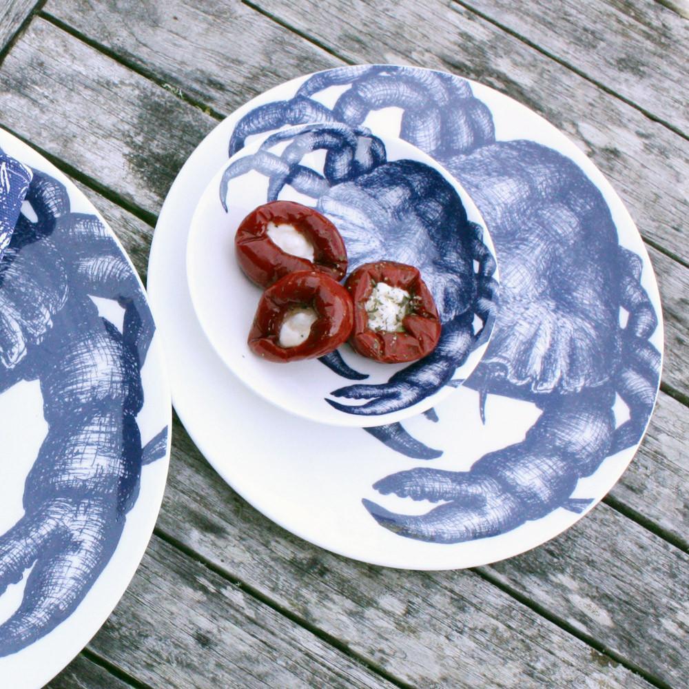 Nibbles bowl in Bone China in our Classic range in Navy and white in the Crab Shell placed on a large matching dinner plate on a wooden table