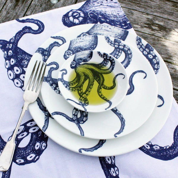Nibbles bowl in Bone China in our Classic range in Navy and white in the Octopus design,this is inside larger matching tableware on a wooden table.