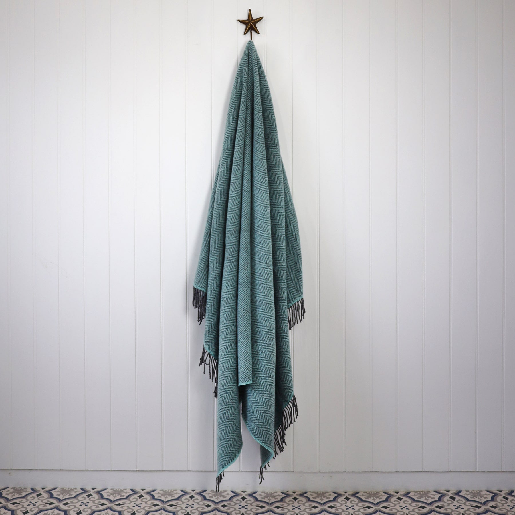Cashmere Throw Duck Egg Herringbone  draped on a Starfish hook against a white tongue and Grooved wall