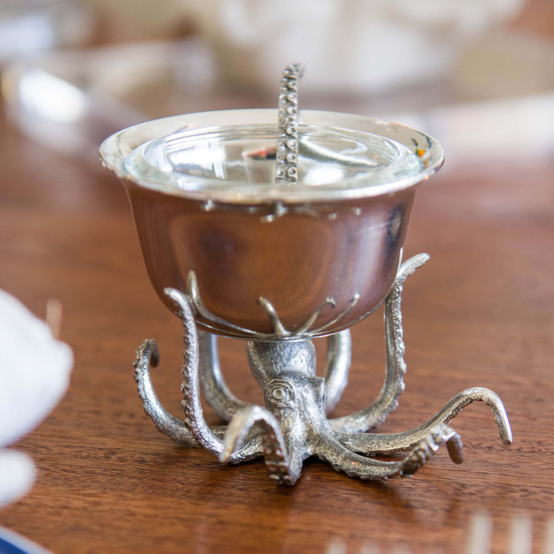 Pewter Octopus condiment bowl with the legs shaped as tentacles and a spoon shaped like a tentacle on a table